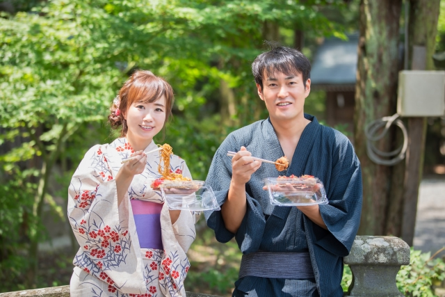 祭りの屋台でタコ焼きを食べる