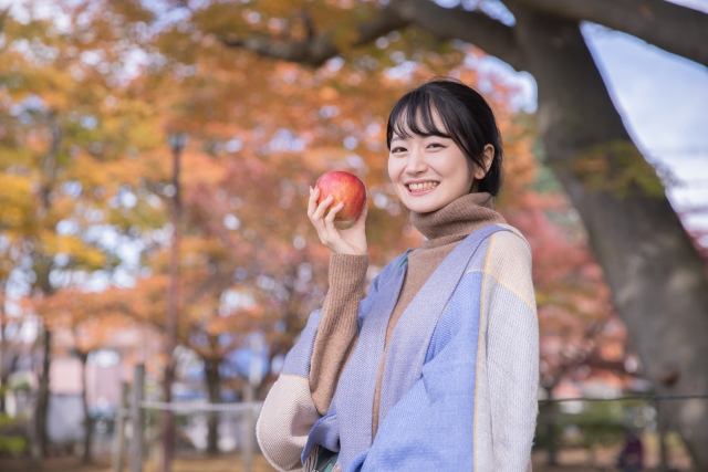 公園でリンゴを食べる女性